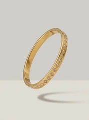 Gold bangle with clear zircons in rhombus shaped settings