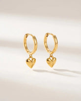 Gold plated hoop earrings with smooth puffed heart drop charms in stainless steel