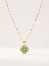 Gold necklace with a green flower pendant on a white background