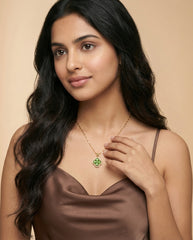 Woman wearing a necklace with a clover pendant against a beige background
