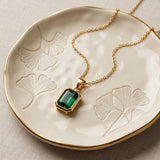 Green Stone Pendant Necklace in a cream ceramic dish with ginkgo leaf detail