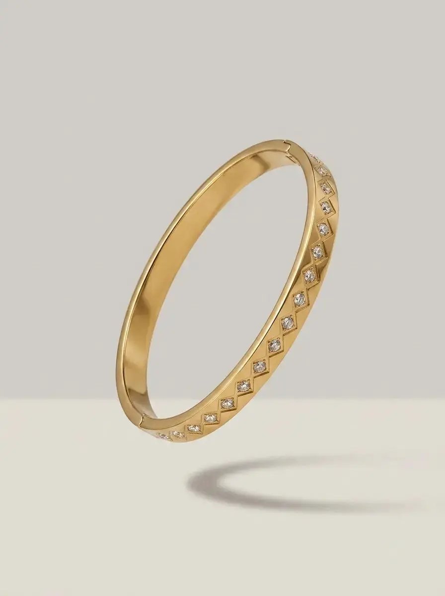 Gold bangle with clear zircons in rhombus shaped settings