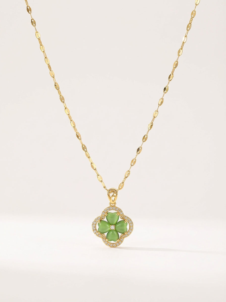 Gold necklace with a green flower pendant on a white background