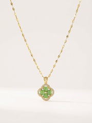 Gold necklace with a green flower pendant on a white background