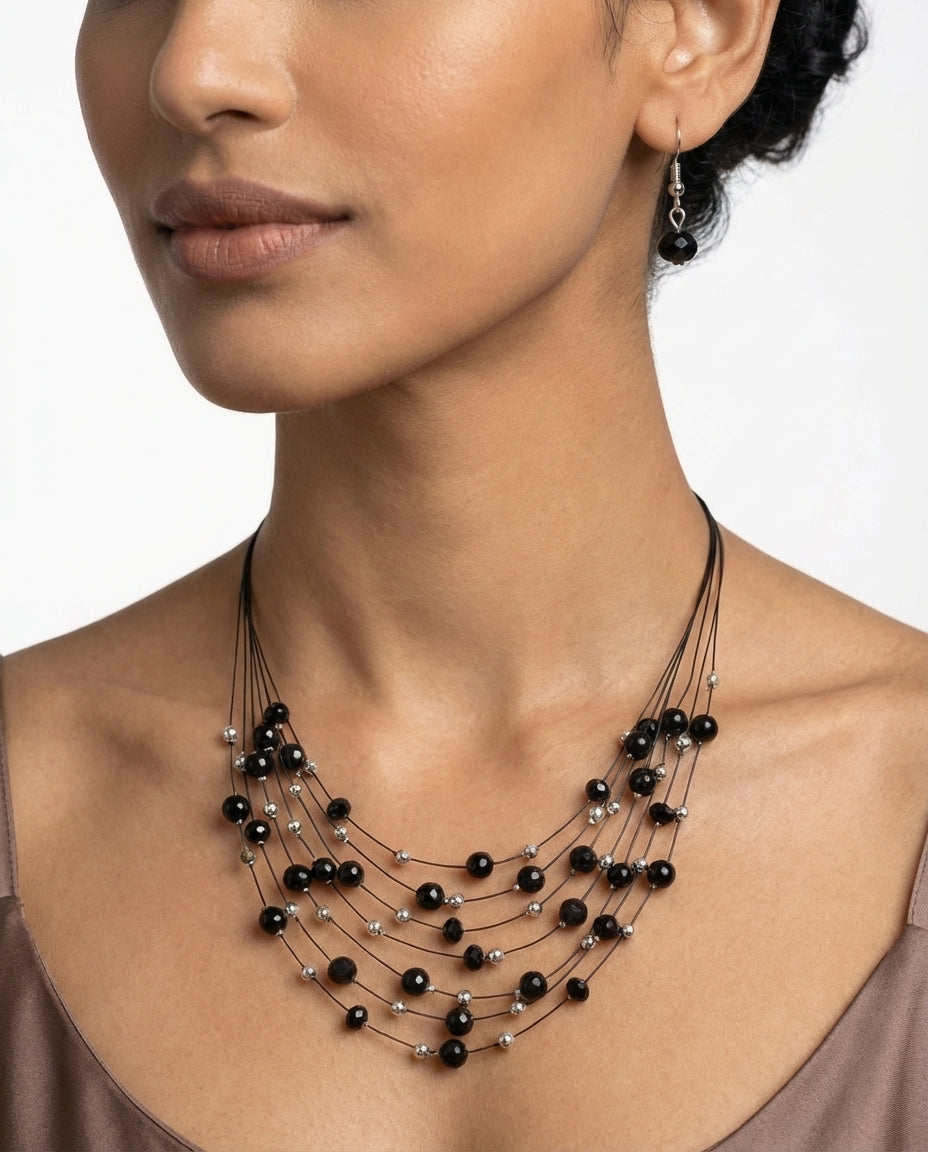 Woman wearing a black beaded necklace on a white background